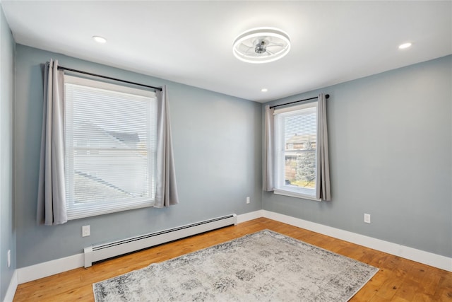 empty room featuring light hardwood / wood-style floors and a baseboard radiator