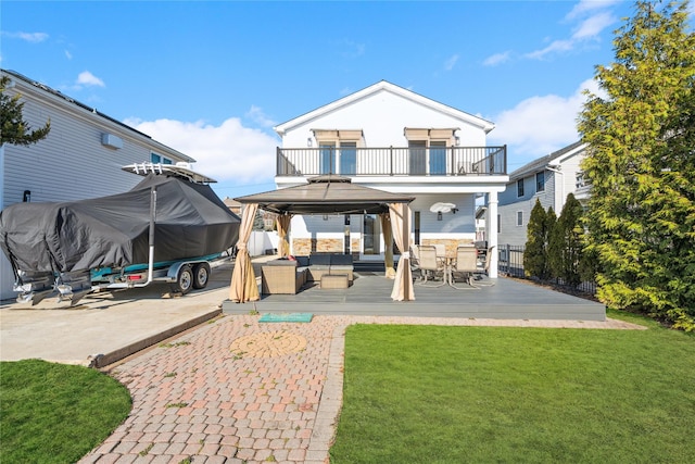 back of house with outdoor lounge area, a yard, a wooden deck, a balcony, and a gazebo