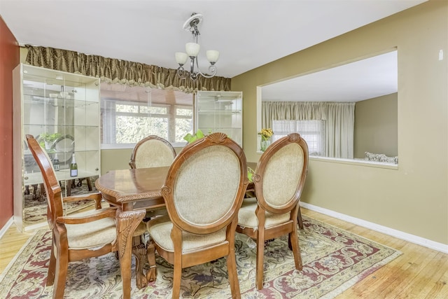 dining space with light wood-type flooring and a chandelier