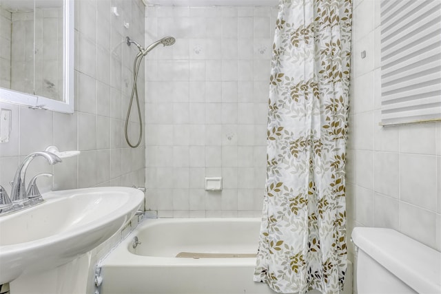 full bathroom featuring toilet, tile walls, shower / bath combo with shower curtain, and sink