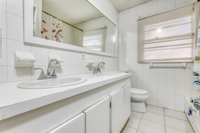 bathroom featuring decorative backsplash, vanity, tile walls, tile patterned flooring, and toilet