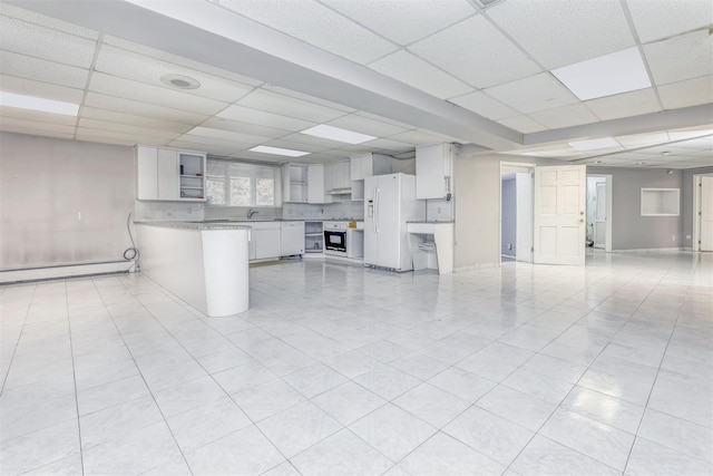 interior space featuring a paneled ceiling, light tile patterned flooring, and baseboard heating