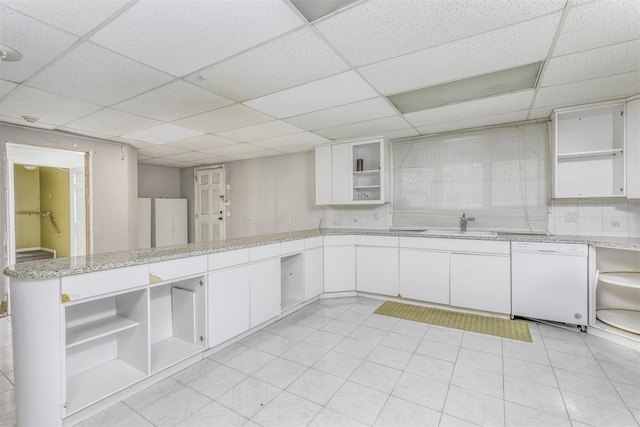 kitchen with white cabinets, a paneled ceiling, kitchen peninsula, and white dishwasher