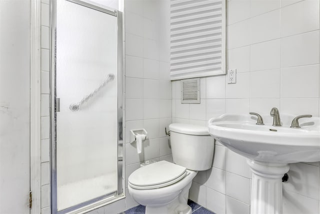 bathroom with toilet, tile walls, and walk in shower