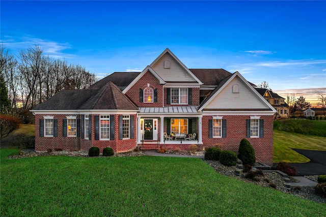 view of front of property with a lawn and a porch