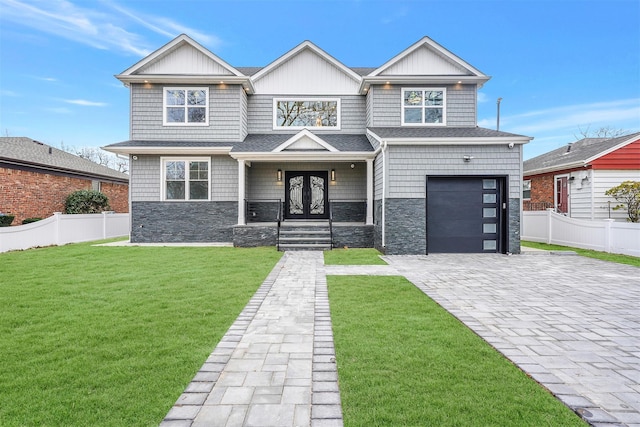 view of front facade featuring a front yard, french doors, and a garage