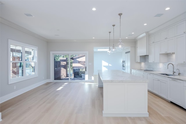 kitchen featuring a center island, decorative light fixtures, light hardwood / wood-style flooring, and sink