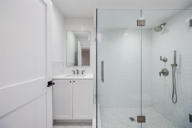 bathroom with tasteful backsplash, vanity, and a shower with shower door