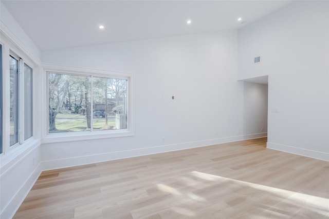 unfurnished room with baseboards, visible vents, light wood finished floors, high vaulted ceiling, and recessed lighting