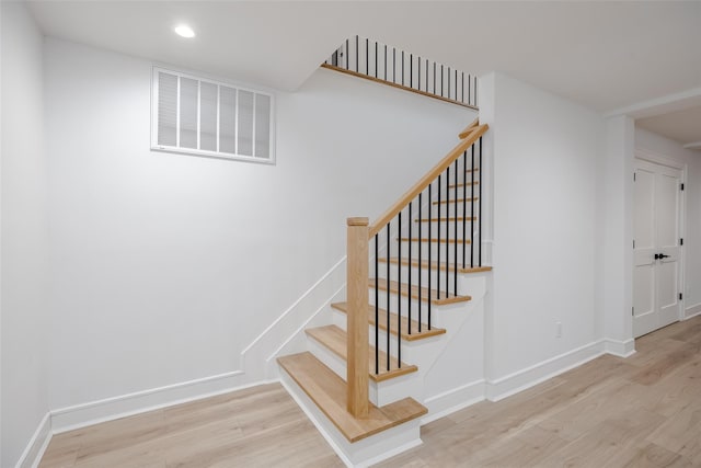 stairway with recessed lighting, visible vents, baseboards, and wood finished floors