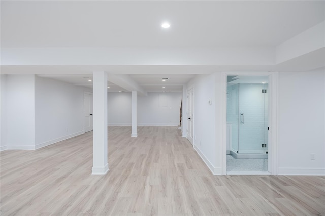 finished below grade area with recessed lighting, light wood-style flooring, and baseboards