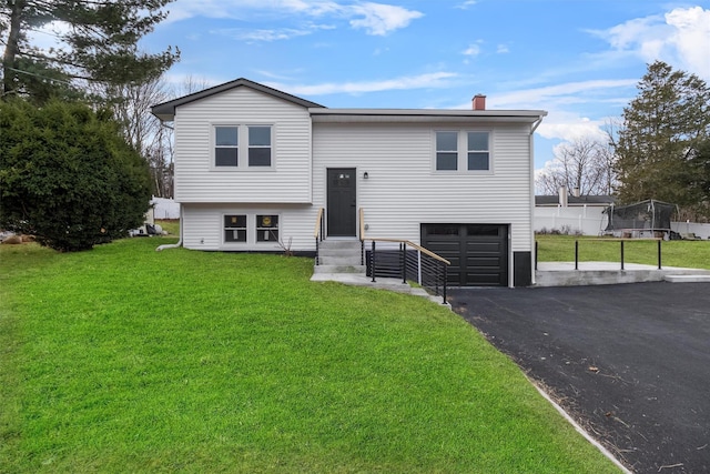 split foyer home featuring a garage and a front lawn