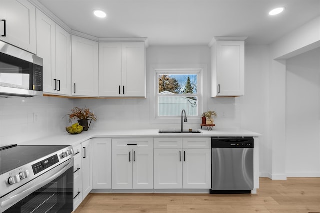 kitchen featuring sink, white cabinetry, stainless steel appliances, and light wood-type flooring