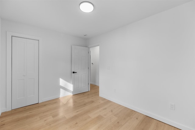 unfurnished bedroom with light hardwood / wood-style flooring and a closet