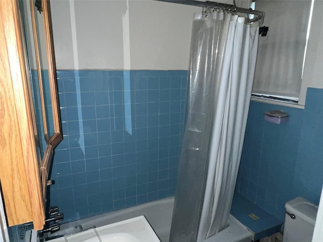 bathroom with shower / bath combination with curtain, toilet, and tile walls