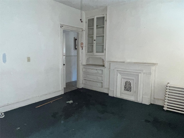 unfurnished living room featuring dark carpet