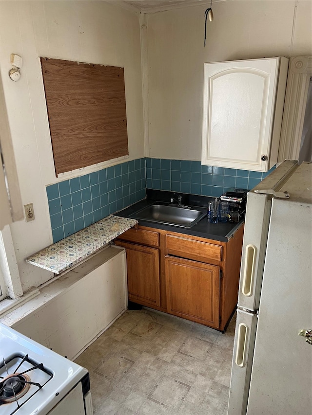 kitchen featuring decorative backsplash, sink, and white appliances