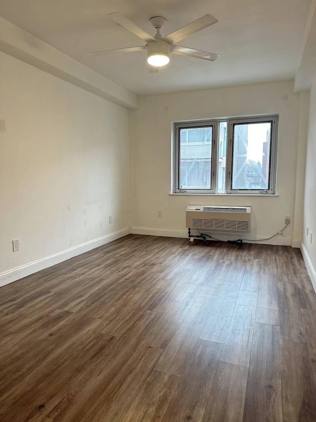 spare room featuring dark hardwood / wood-style floors, ceiling fan, and a wall unit AC