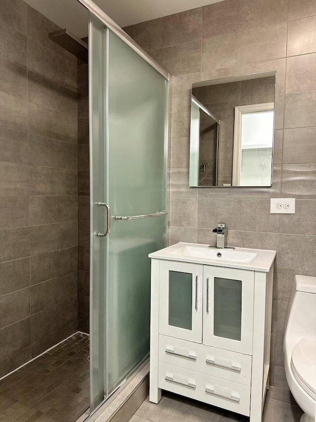 bathroom featuring an enclosed shower, vanity, toilet, and tile walls