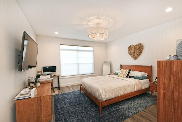 bedroom with a chandelier and wood-type flooring