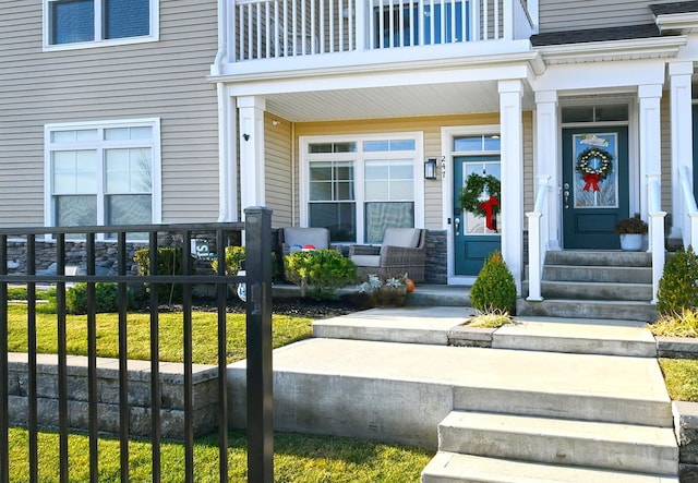 entrance to property featuring a balcony and covered porch