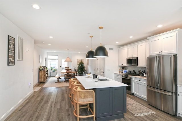 kitchen with a center island with sink, white cabinetry, and appliances with stainless steel finishes