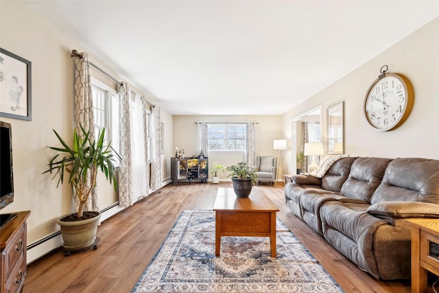 living room with light hardwood / wood-style flooring and a baseboard heating unit