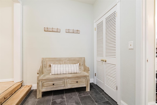 mudroom with dark tile patterned floors