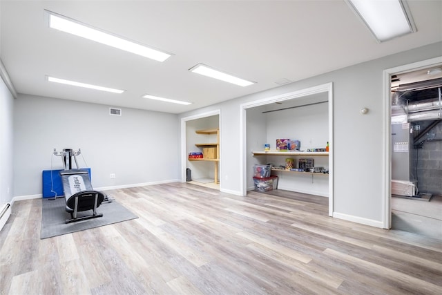 workout room with light hardwood / wood-style flooring