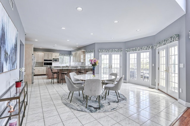 dining space with french doors and light tile patterned floors