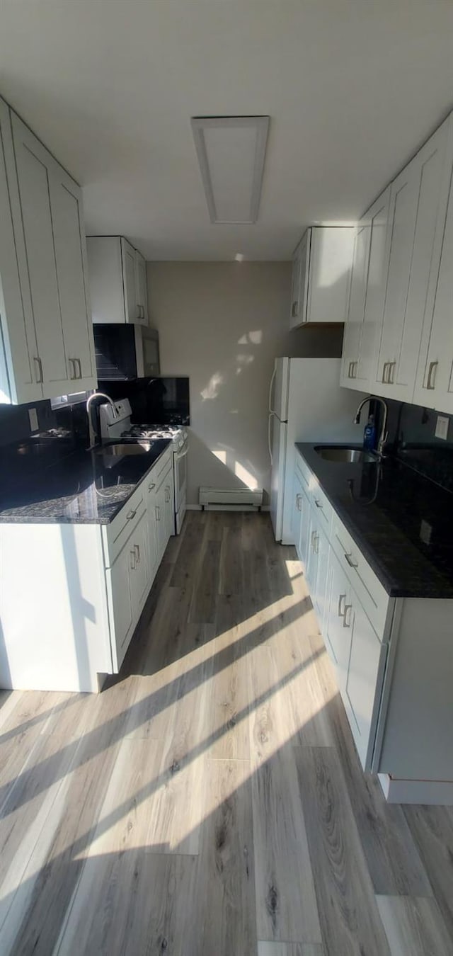 kitchen with sink, white cabinets, dark wood-type flooring, and a baseboard radiator