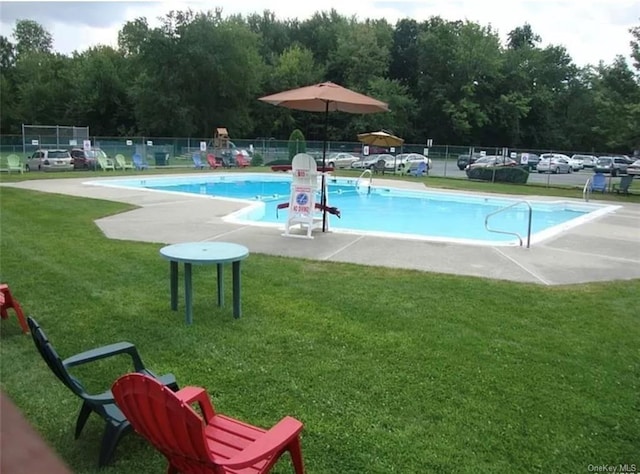 view of swimming pool featuring a lawn and a patio