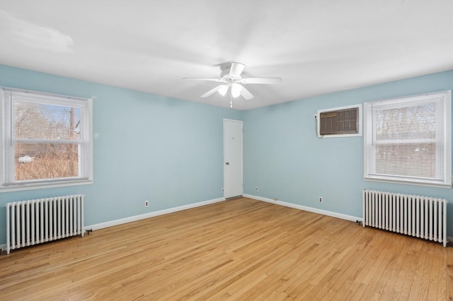 unfurnished room featuring a wall mounted air conditioner, radiator heating unit, light hardwood / wood-style flooring, and ceiling fan