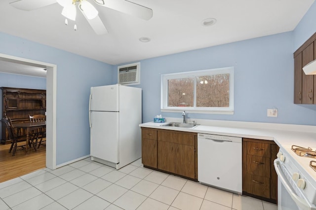 kitchen featuring a wall mounted air conditioner, white appliances, ceiling fan, sink, and light tile patterned floors