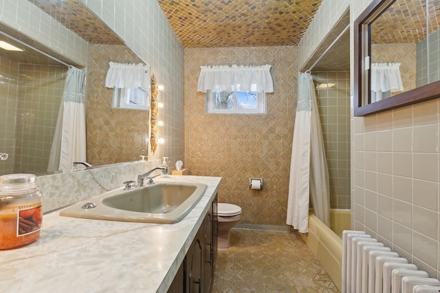 full bathroom featuring vanity, toilet, tile walls, shower / tub combo with curtain, and radiator heating unit