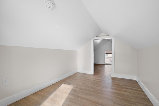 additional living space with vaulted ceiling and hardwood / wood-style floors