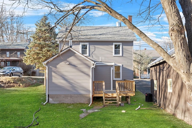 back of property featuring a wooden deck and a yard