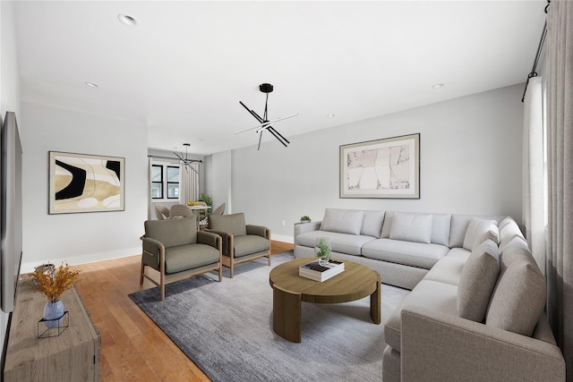 living room featuring a notable chandelier and light hardwood / wood-style flooring