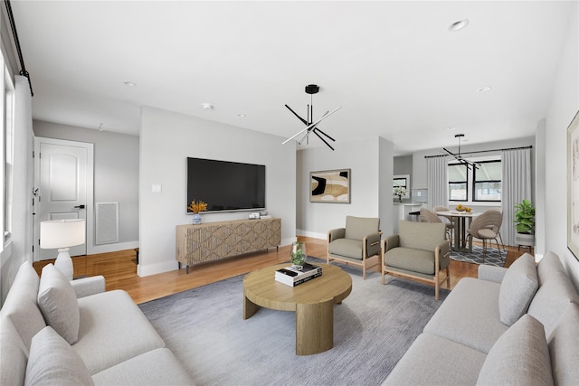 living room with hardwood / wood-style floors and an inviting chandelier