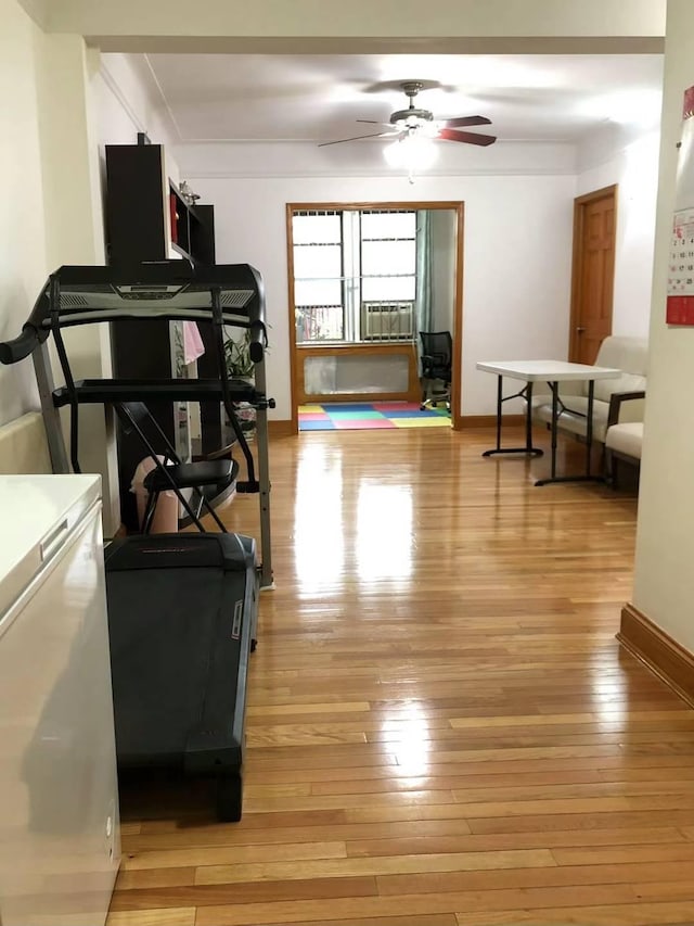 workout room featuring light hardwood / wood-style flooring, ceiling fan, and cooling unit