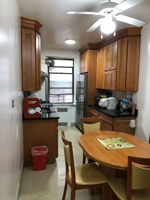 kitchen featuring stainless steel fridge with ice dispenser, light tile patterned floors, radiator, and ceiling fan