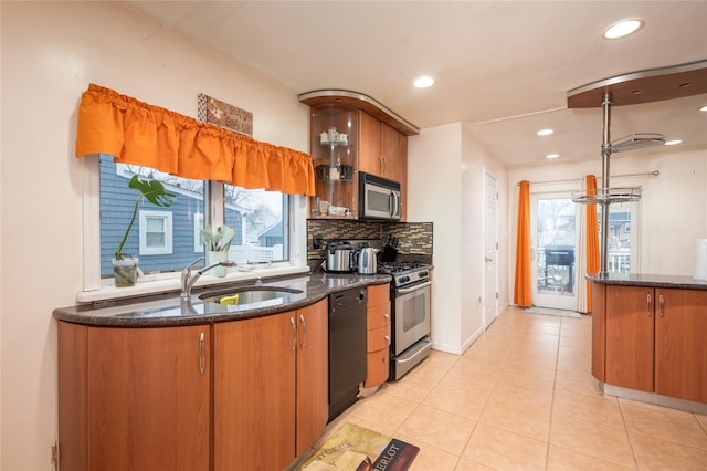 kitchen featuring light tile patterned flooring, sink, backsplash, and appliances with stainless steel finishes