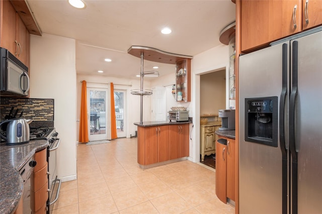 kitchen with backsplash, light tile patterned floors, decorative light fixtures, kitchen peninsula, and stainless steel appliances