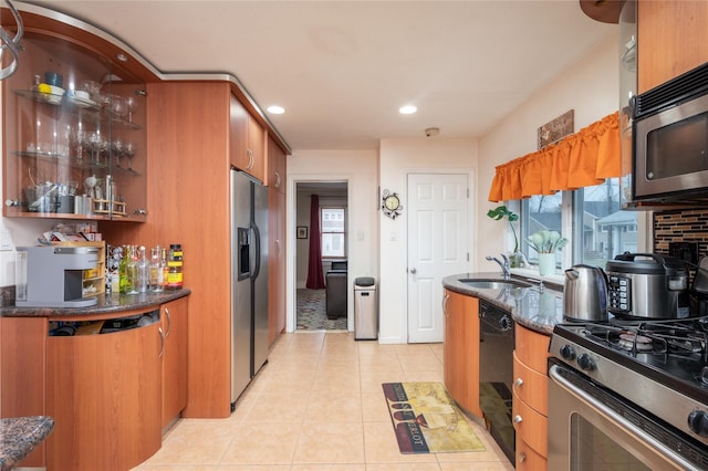 kitchen with a healthy amount of sunlight, sink, light tile patterned flooring, and stainless steel appliances