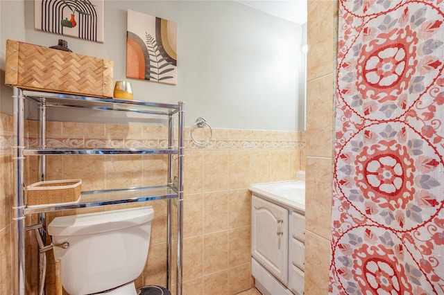 bathroom featuring vanity, toilet, tile walls, and a tile shower