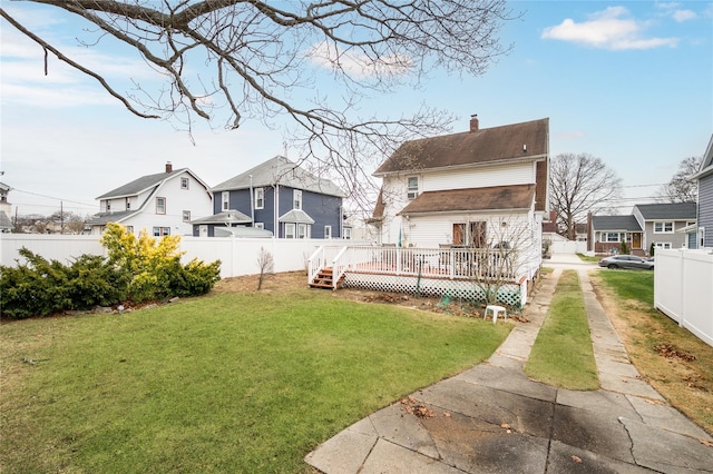 rear view of house with a yard and a wooden deck