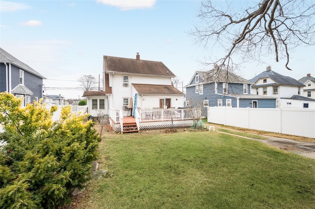 back of property featuring a yard and a wooden deck