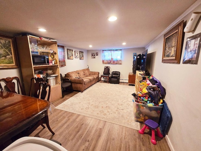 living room featuring hardwood / wood-style flooring, ornamental molding, a textured ceiling, and a baseboard heating unit