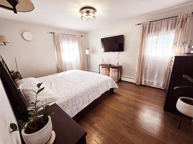 bedroom featuring baseboard heating and dark wood-type flooring