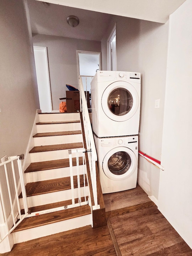 laundry room with stacked washer and dryer and dark wood-type flooring